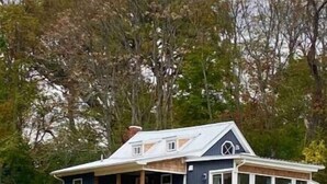 Une maison à deux étages avec un balcon et une véranda couverte.