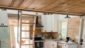 Un salon confortable avec un canapé, une table basse et une cuisine en arrière-plan.