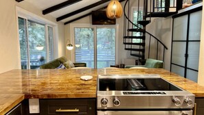 A kitchen with a built-in stove, oven, and a wooden countertop.
