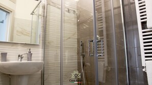 A modern bathroom with a glass shower enclosure, a white sink, and a towel rack. - CASA DEGLI AMICI (Ruvo di Puglia)