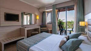 A hotel room with a large bed, a desk, a TV, and a balcony with outdoor seating. - Palmeras Beach Hotel (Alanya)