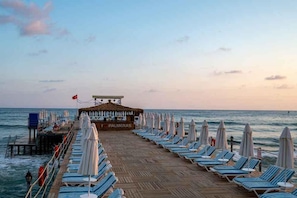 Relax on the beach with comfortable sun loungers and umbrellas, steps from the ocean.