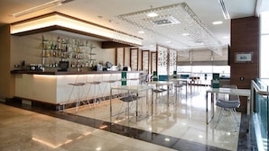 A modern bar area with a counter, stools, and a variety of bottles. - Tuyap Palas (Istanbul)
