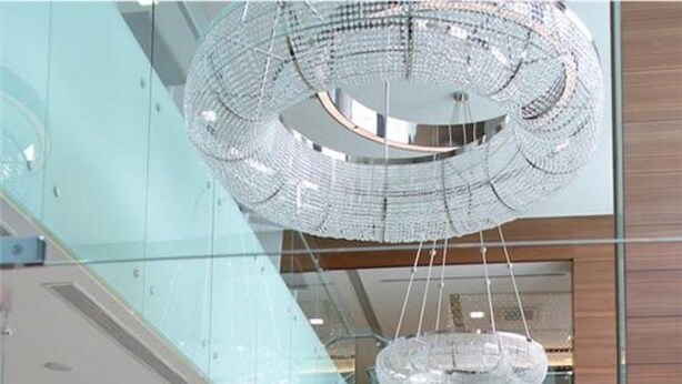 A modern interior with a spiral staircase, a chandelier, and a reception area. - Tuyap Palas (Istanbul)