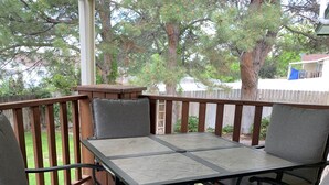 A covered patio with a wooden table and four grey upholstered chairs. - Sunny Days! Room for everyone and Pet-Friendly! (Pocatello)