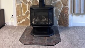 A wood-burning stove with a stone wall background. - Sunny Days! Room for everyone and Pet-Friendly! (Pocatello)