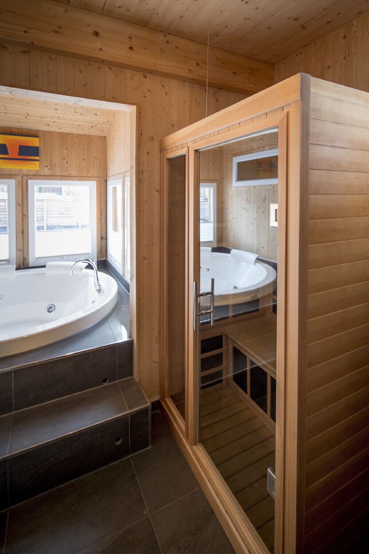Ein modernes Badezimmer mit Holzvertäfelung, einer freistehenden Badewanne und einer Duschkabine.
