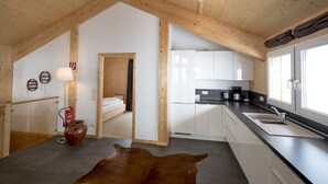 Eine moderne Küche mit weißen Schränken, einer schwarzen Arbeitsplatte und einem großen Fenster.