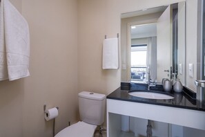 A bathroom with a toilet, a sink, a mirror, and a towel rack. - Vita Bom Retiro (São Paulo)