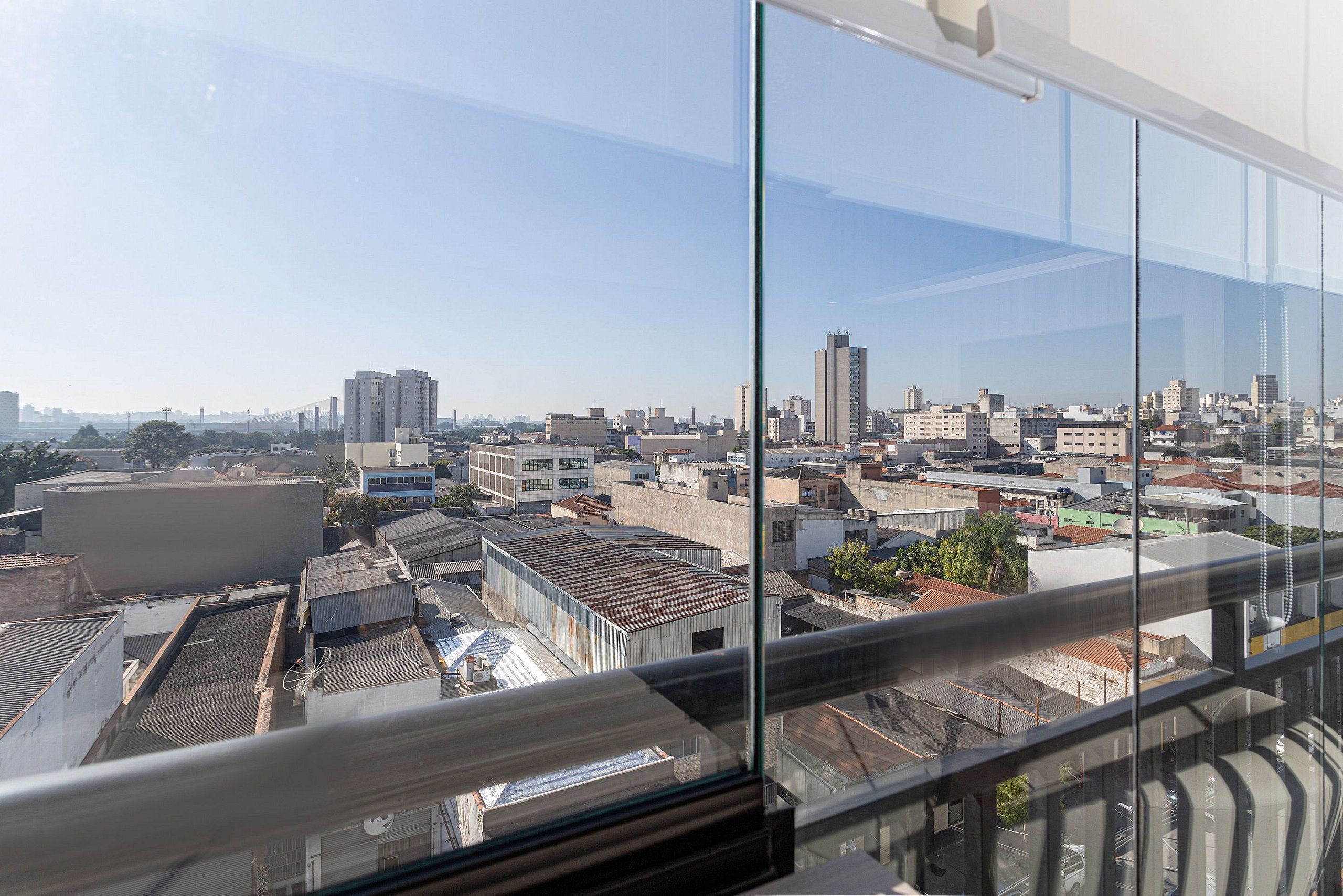Une vue panoramique sur la ville, prise depuis un immeuble de grande hauteur, avec de nombreux bâtiments et un ciel dégagé.