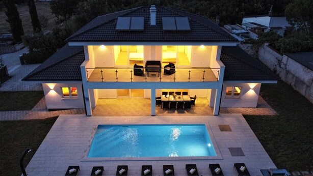 Ett tvåvåningshus med en swimmingpool och en uteplats.