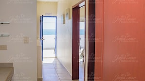 A hallway leading to a balcony with a view of the sea.