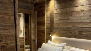A bedroom with a wooden headboard, a bed with white bedding, and a bedside lamp. - Apartment chalet vallée d'incles Andorra (Canillo)