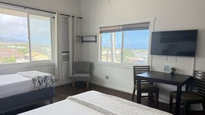 A room with two beds, a desk, a chair, and a TV. - Unit 27 Waena Inn - Maui Private Suite (Wailuku)