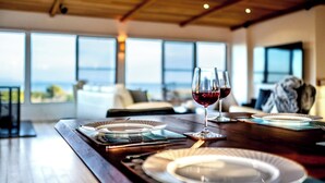 Une table à manger dressée avec des assiettes et des verres, offrant une vue panoramique.