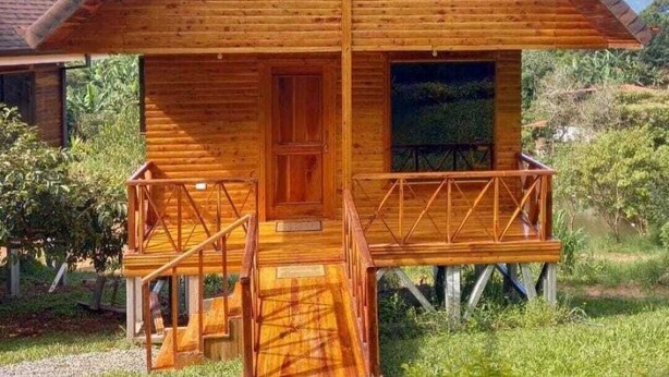 A wooden cabin with a balcony, a front door, and a window. - Cabañas La Laguna Lodge (Corralillo)
