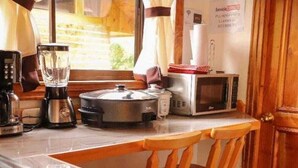 A compact kitchen with a sink, a blender, a microwave, and a kettle. - Cabañas La Laguna Lodge (Corralillo)