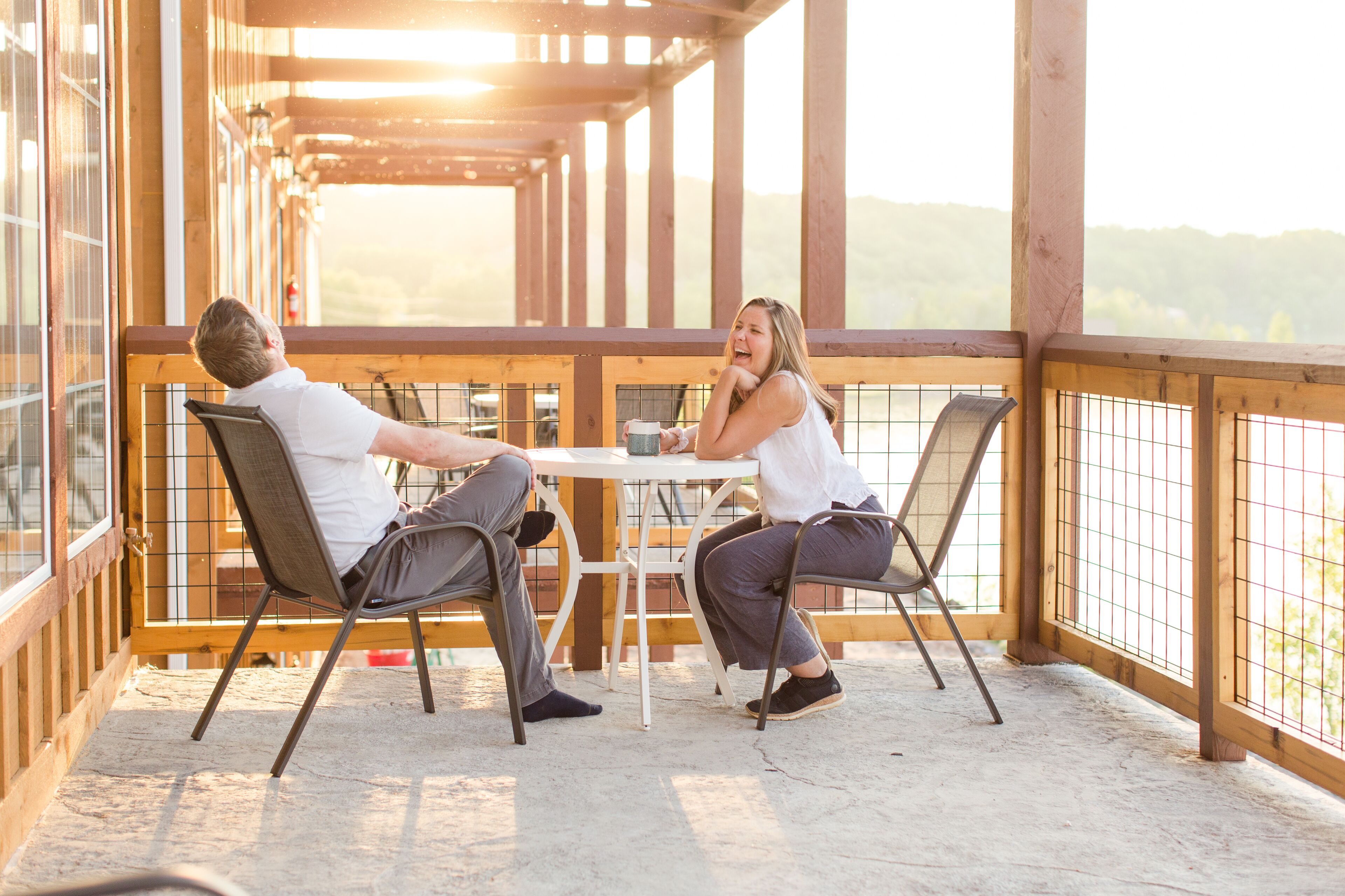 Une terrasse en bois avec une table et des chaises, offrant une vue sur un paysage magnifique.