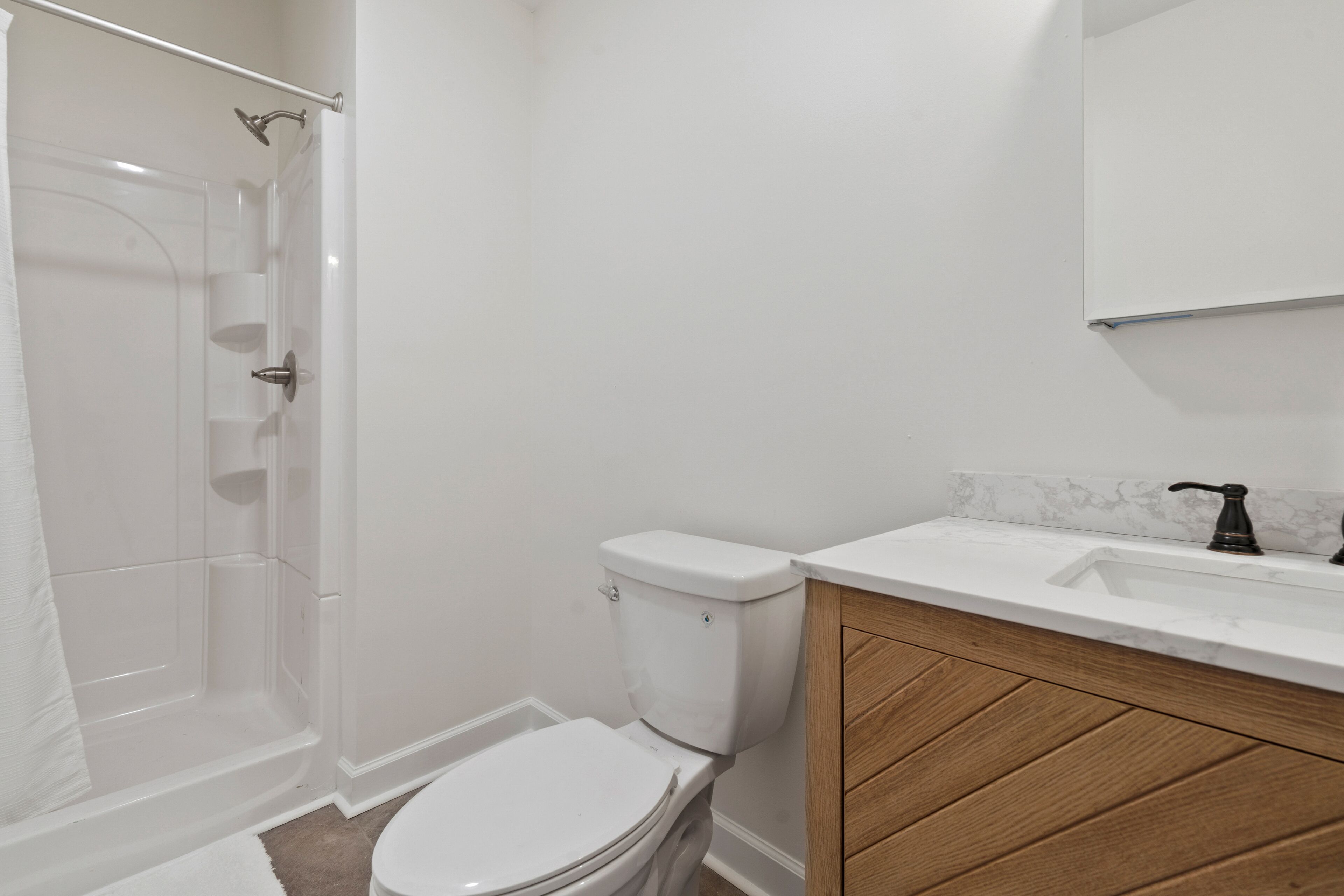 Un baño con inodoro, ducha y lavamanos.