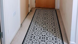 A hallway with a patterned carpet, a door with a peephole, a wall-mounted light fixture, and a framed picture. - 9 mins from the northern line station. 2 mins from 3 B/stops and local amenities (London)