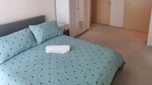 A bedroom with a bed, a wardrobe, a door, and a hanging light fixture. - 9 mins from the northern line station. 2 mins from 3 B/stops and local amenities (London)