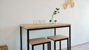 Une table en bois avec deux bancs, un vase avec une plante et un élément décoratif fixé au mur.