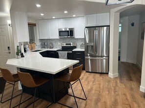 Enjoy cooking in this well-lit kitchen with a spacious island and stainless steel appliances.