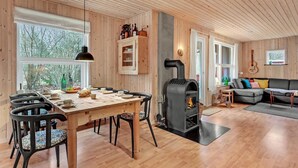 Ein gemütliches Blockhaus-Interieur mit Essbereich, Kamin und Wohnbereich.