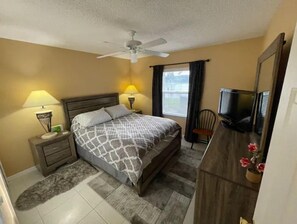 Cozy retreat with a single bed, nightstand, and TV.