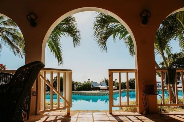 Relax by the serene pool, surrounded by arches and lush views.
