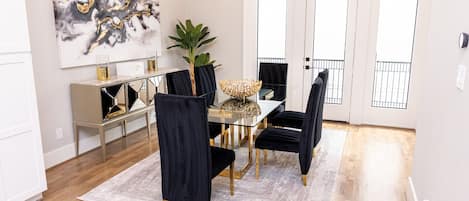 A dining area with a glass table, black chairs, and a decorative centerpiece.
