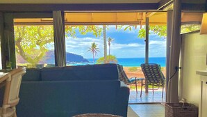 Un salon avec un canapé, une table en verre et une vue sur l’océan.
