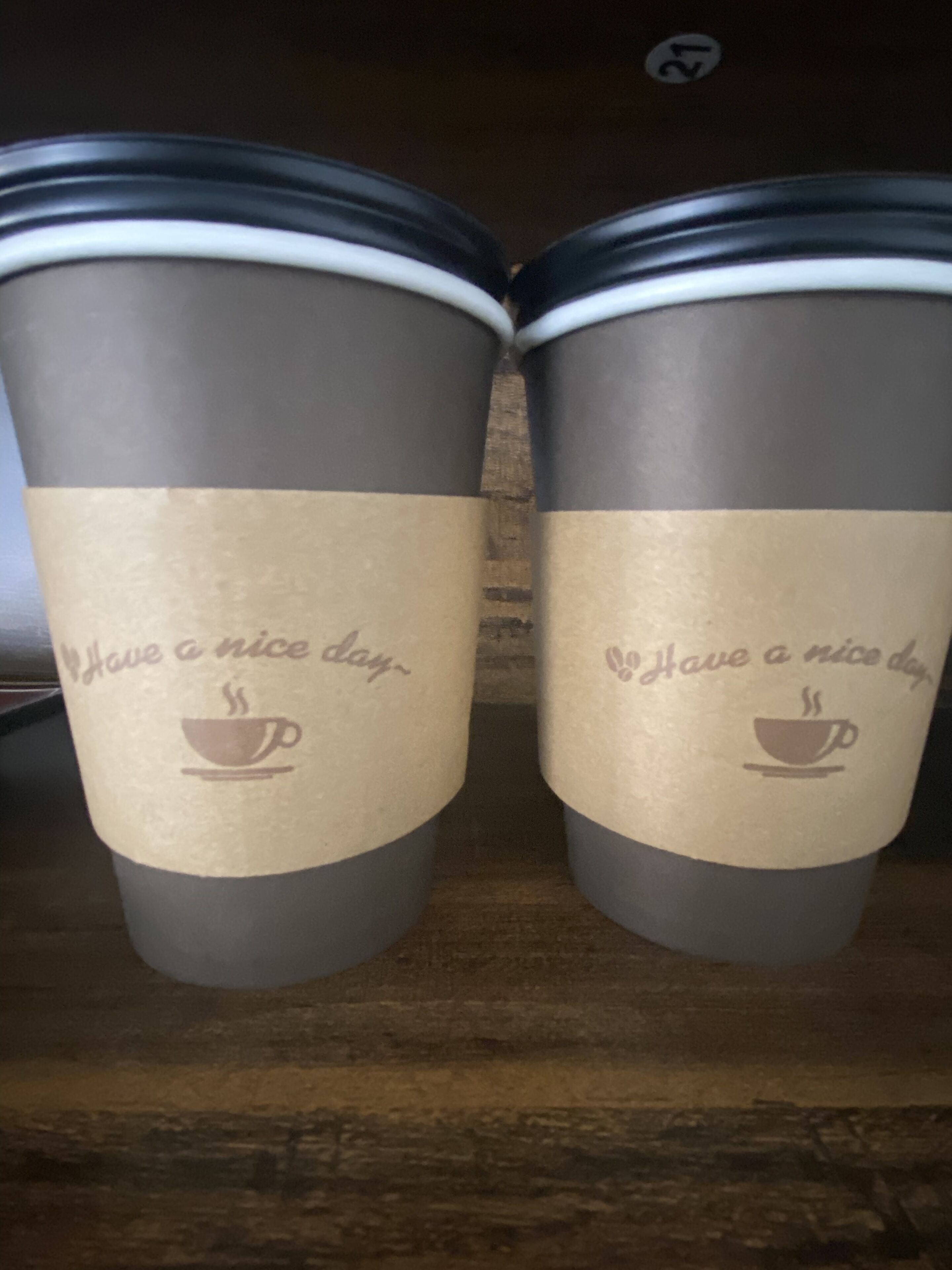 Dues tasses de cafè amb tapa sobre una prestatgeria.
