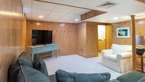 A room with a television, a desk, a sofa, and a chair. - Gorgeous Home with Game Room Dog Welcome! (Chatham)