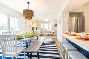 Enjoy meals in this stylish kitchen and dining area, featuring a stainless steel refrigerator and comfortable seating for a relaxing meal.