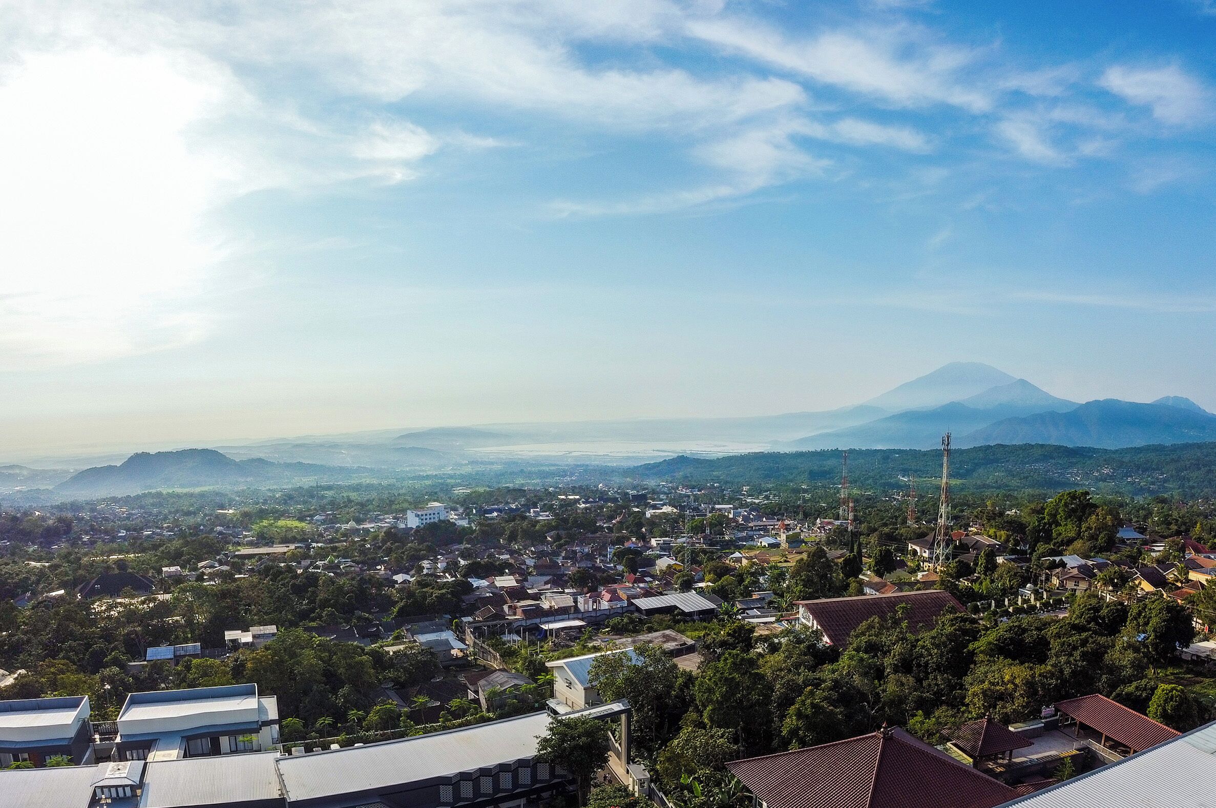 A panoramic view of a town with a prominent mountain in the background.