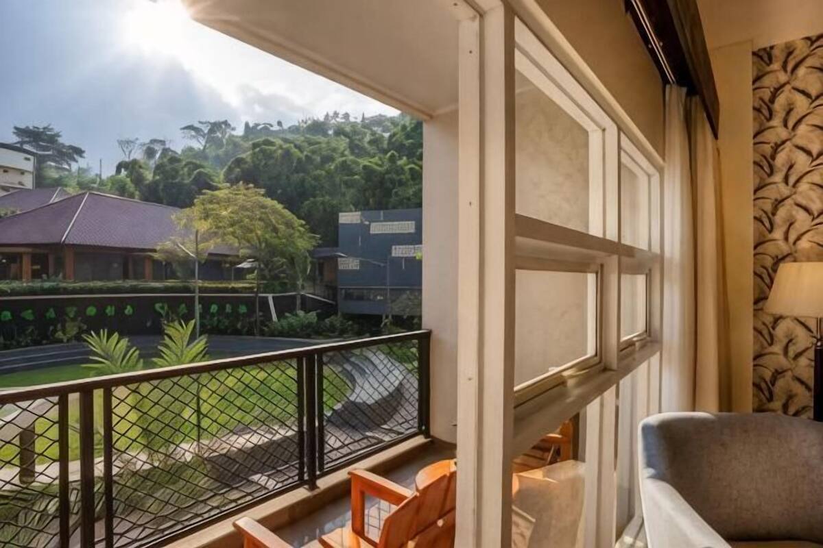 Un balcón con vista a un patio, una silla y una lámpara.
