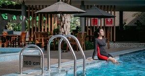 A person sitting by a pool with a sign indicating 160 cm depth. - Griya Persada Convention Hotel & Resort (Bandungan)