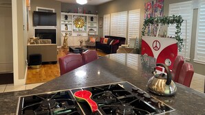 A modern kitchen with a central island, stainless steel appliances, and a decorative watermelon-shaped pot.