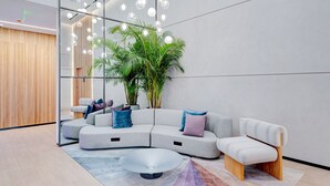 Una sala moderna con un sofá seccional, una mesa de centro y una planta en maceta.