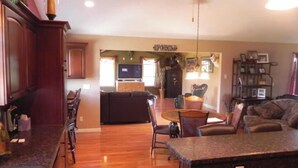 A spacious living area with a kitchen, dining area, and a seating area with a fireplace.