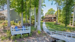 A residential property with a white deck, a stone bridge over a stream, and a well-maintained lawn. - Sunny Daze by SoCharm | Hot Tub | Fire Pit | Dock | Great Views (Denver)