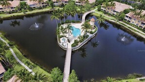 Een resort met een centraal waterlandschap, diverse zwembaden en palmbomen.