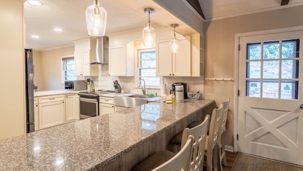 A modern kitchen with granite countertops, stainless steel appliances, and pendant lighting. - Charming Mountain Cabin Near Boone (Boone)