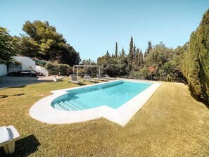 Relax by the pool surrounded by lush greenery and lounge in style.
