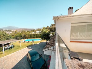 Relax by the pool surrounded by a well-manicured lawn and lounge chairs, with a view of the surrounding landscape and mountains.