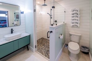 Regadera, secadora de cabello, toallas, papel de baño 