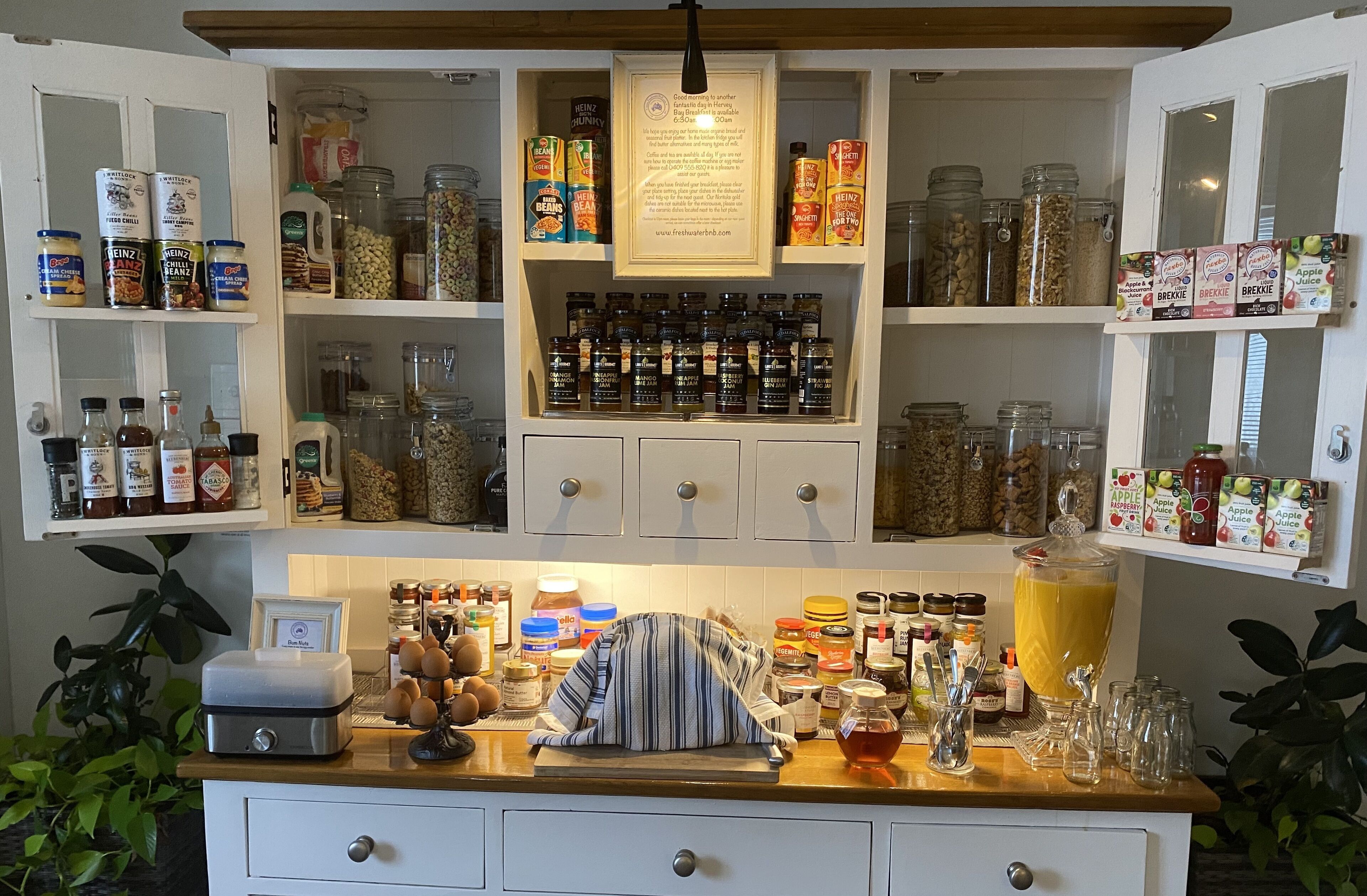 A kitchen with shelves stocked with jars of spices, condiments, and canned goods.