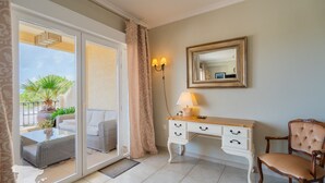 A room with a sliding glass door leading to a balcony, a white console table with a lamp, a mirror, and a tufted chair. - CostaBlancaDreams - Dinamarca in Altea Hills (Altea)