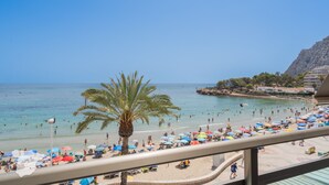 A beach with palm trees, umbrellas, and people. - CostaBlancaDreams - Nineteen / Frentemar in Calpe (Calpe)